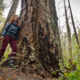 Benna Keoghoe stands next to a giant Douglas fir measuring 6ft in diameter growing in Mount Doug Park located within the Oak Bay/Gordon Head swing riding.