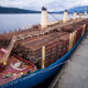 A ship loaded with raw logs sits docked in Port Alberni on Feb 24
