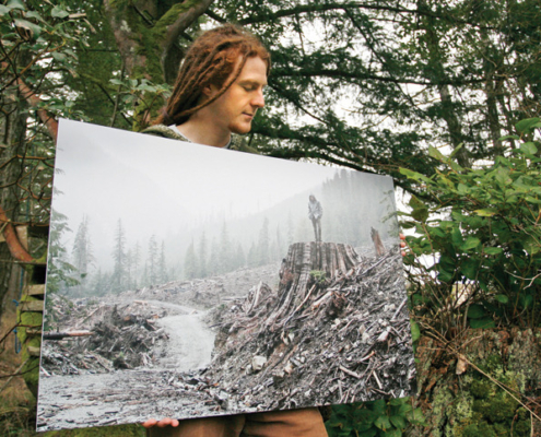 AFA photographer TJ Watt shows a print of his photo of a man on a stump in the Gordon River valley that won first place in a Outdoor Photography Canada magazine photo contest.